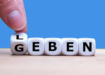 Fünf Würfel die je nachdem wie der erste Würfel gedreht wird, entweder das Wort "Leben" oder "Geben" ergeben.